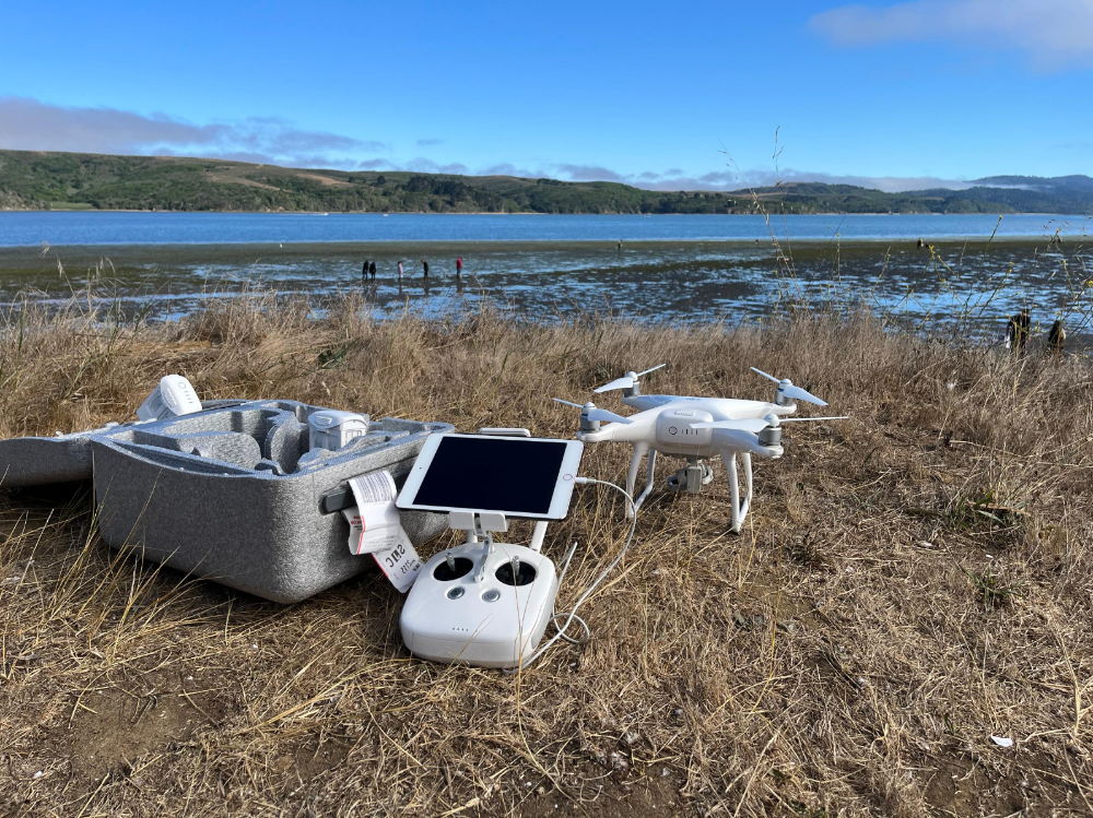 A picture showing drone and its remote controller placed on the ground